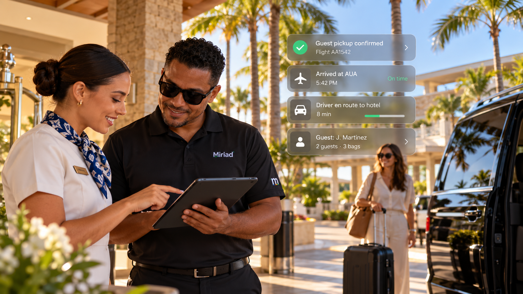 Miriad-branded driver and resort staff member reviewing guest pickup details together on a tablet.