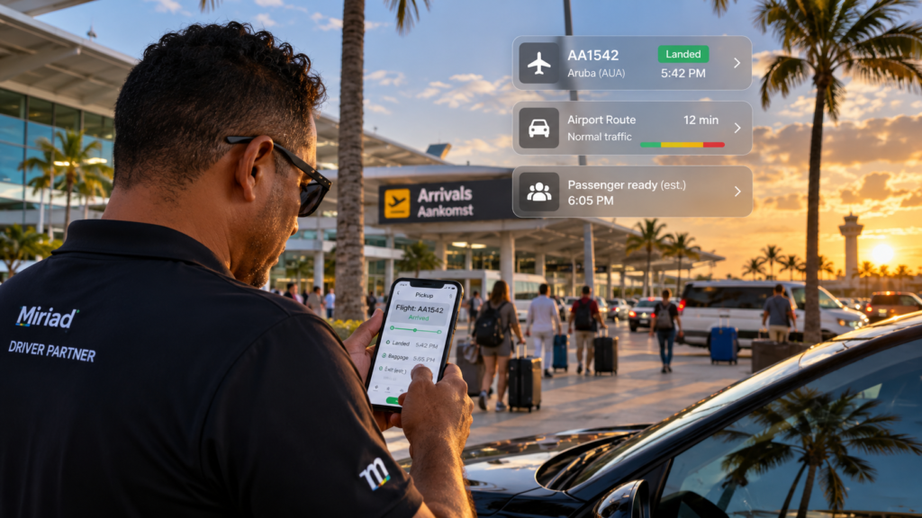 Miriad-branded driver checking airport pickup information on a phone outside arrivals in Aruba.